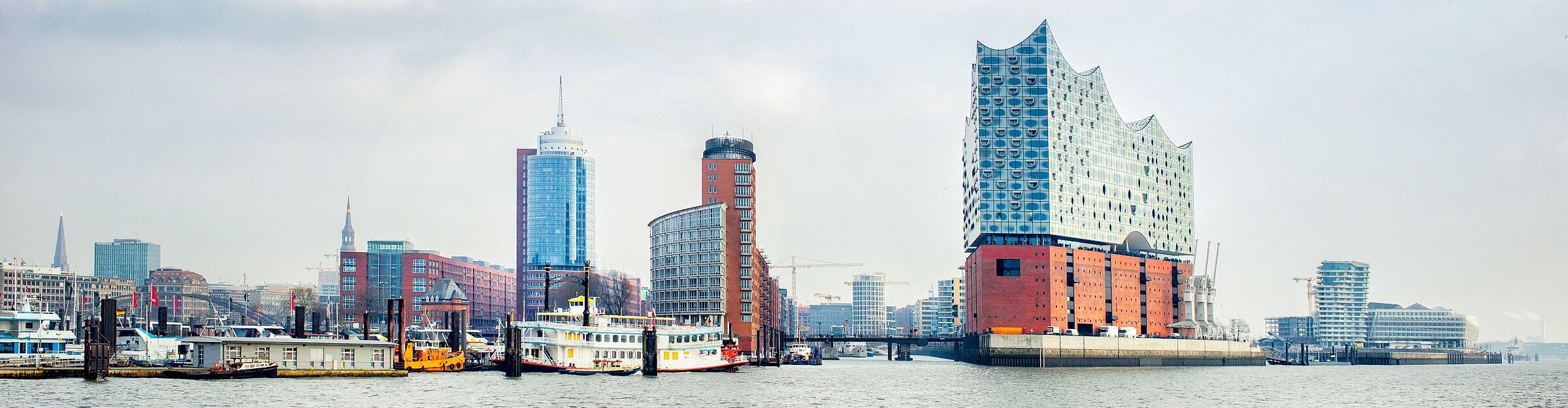 Panorama von Hamburg mit Elbphilharmonie und Hafenanlagen an der Elbe.